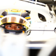 A photo of Nyck de Vries sat in an Alpha Tauri F1 car in the paddock.